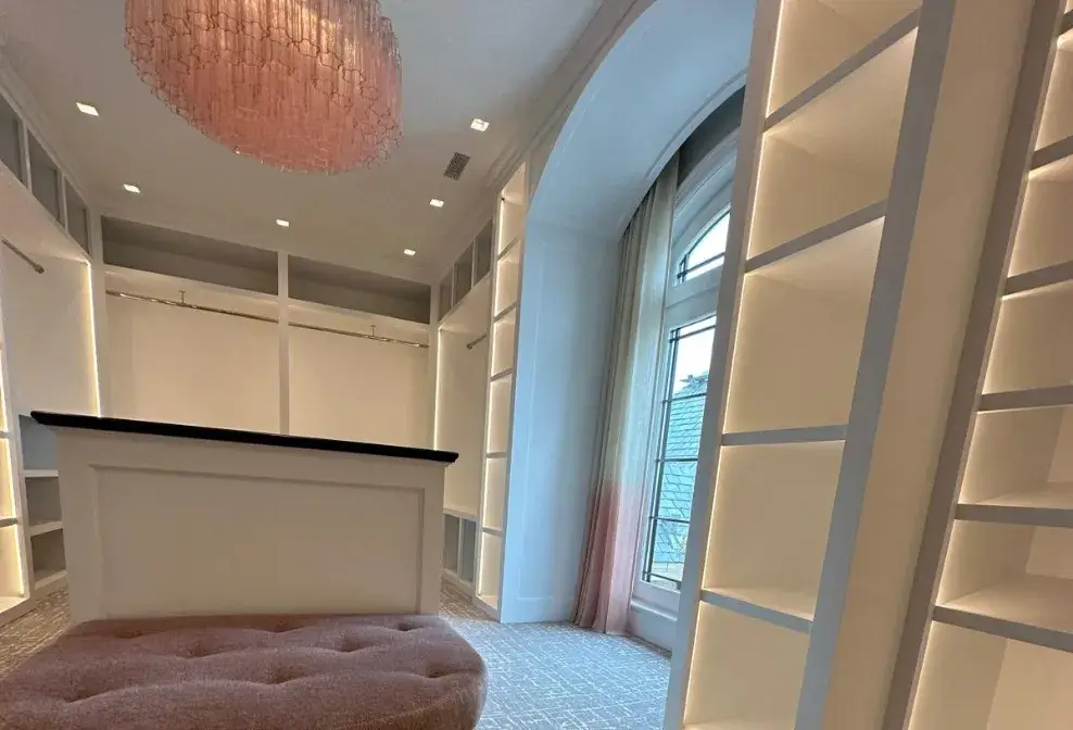Luxurious walk-in closet with custom shelving and built-in lighting