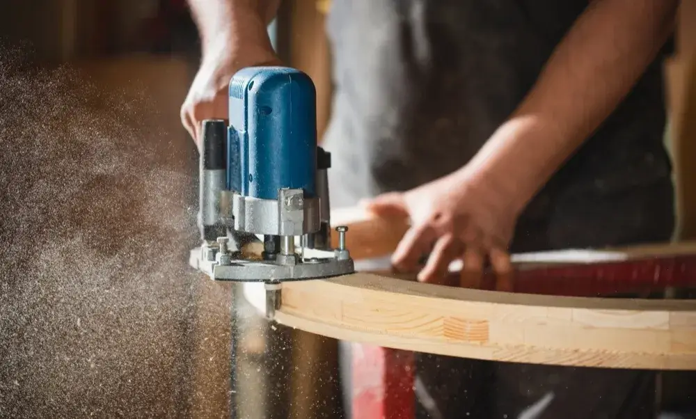 Carpenter shaping wood edge with a router tool