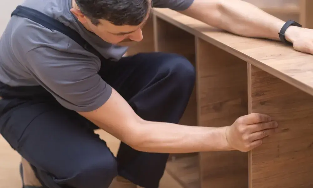 Carpenter inspecting wood shelving installation