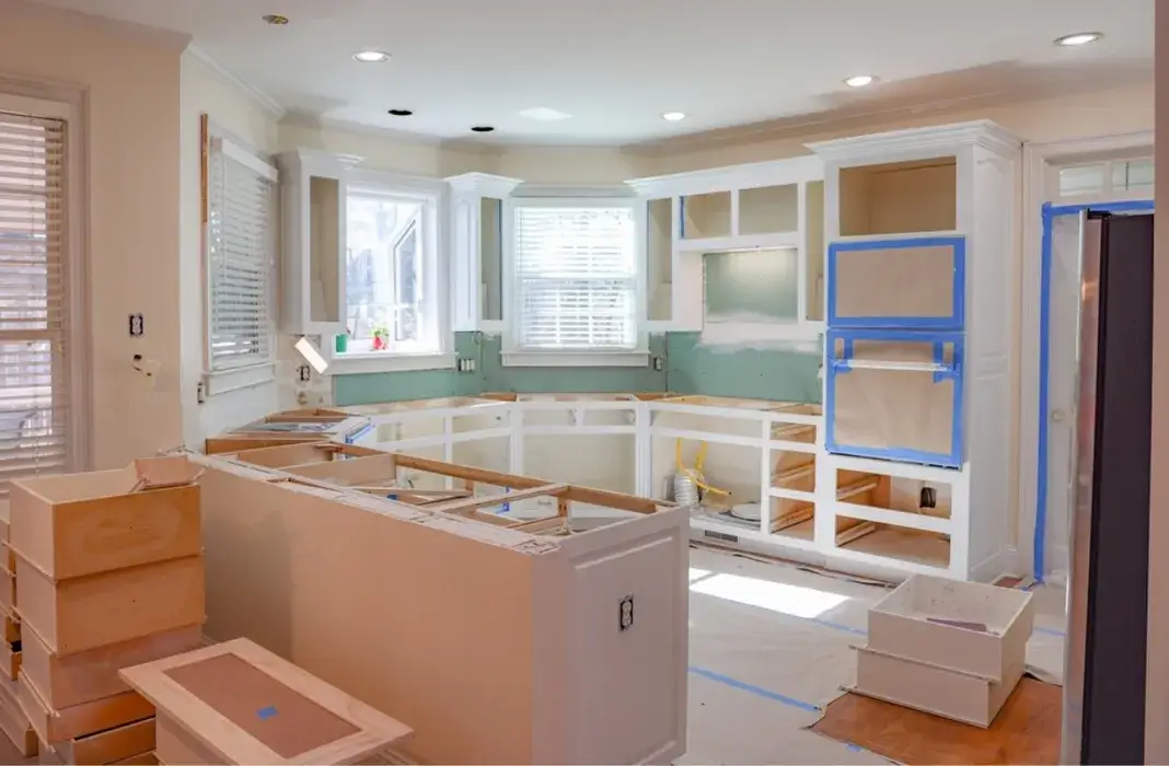 Residential kitchen under construction with white built-in cabinets