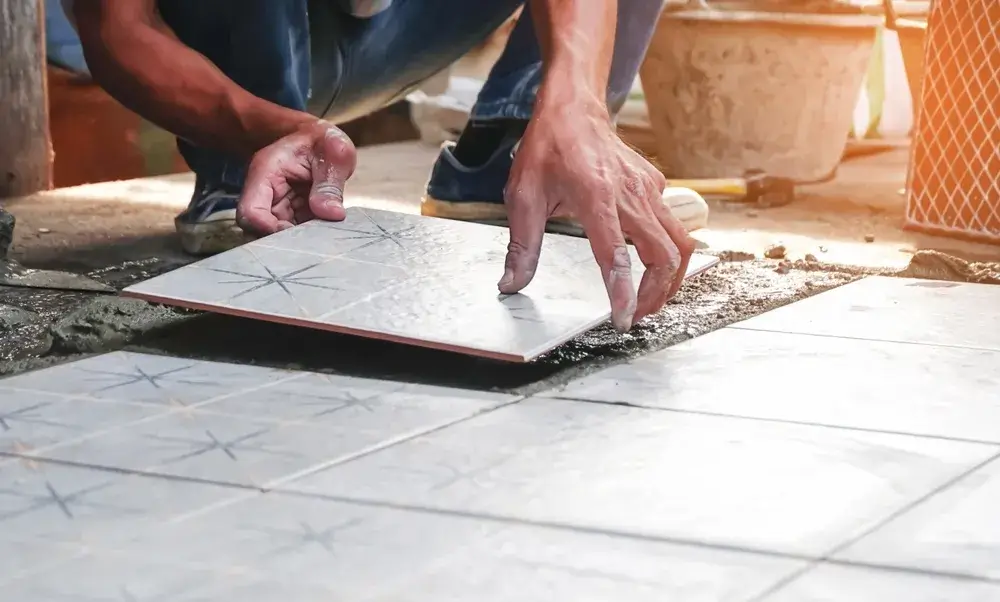 Close-up of tile being installed on cement floor